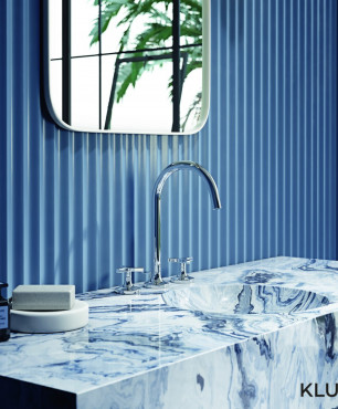 Urocza łazienka w niebieskim kolorze z kamiennym blatem z okrągłym zlewem
