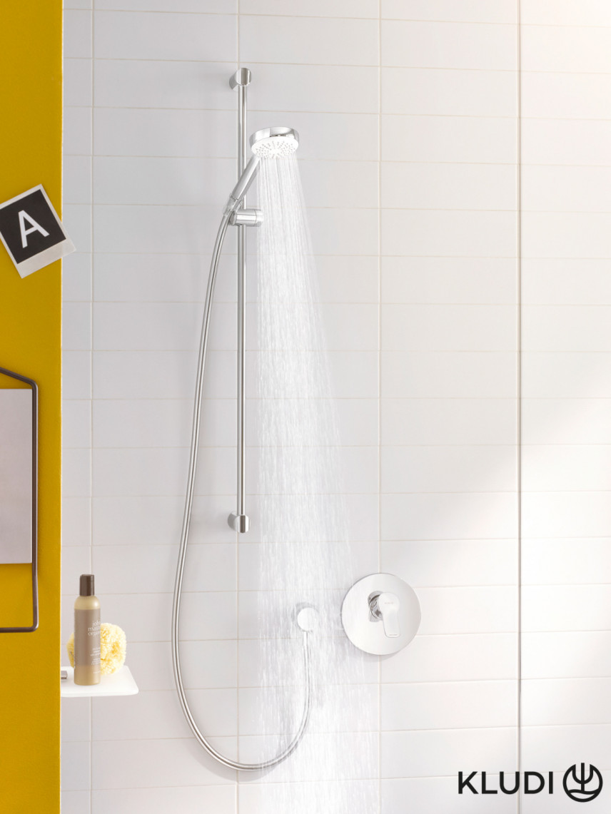 Łazienka z białymi płytkami na ścianie pod prysznicem