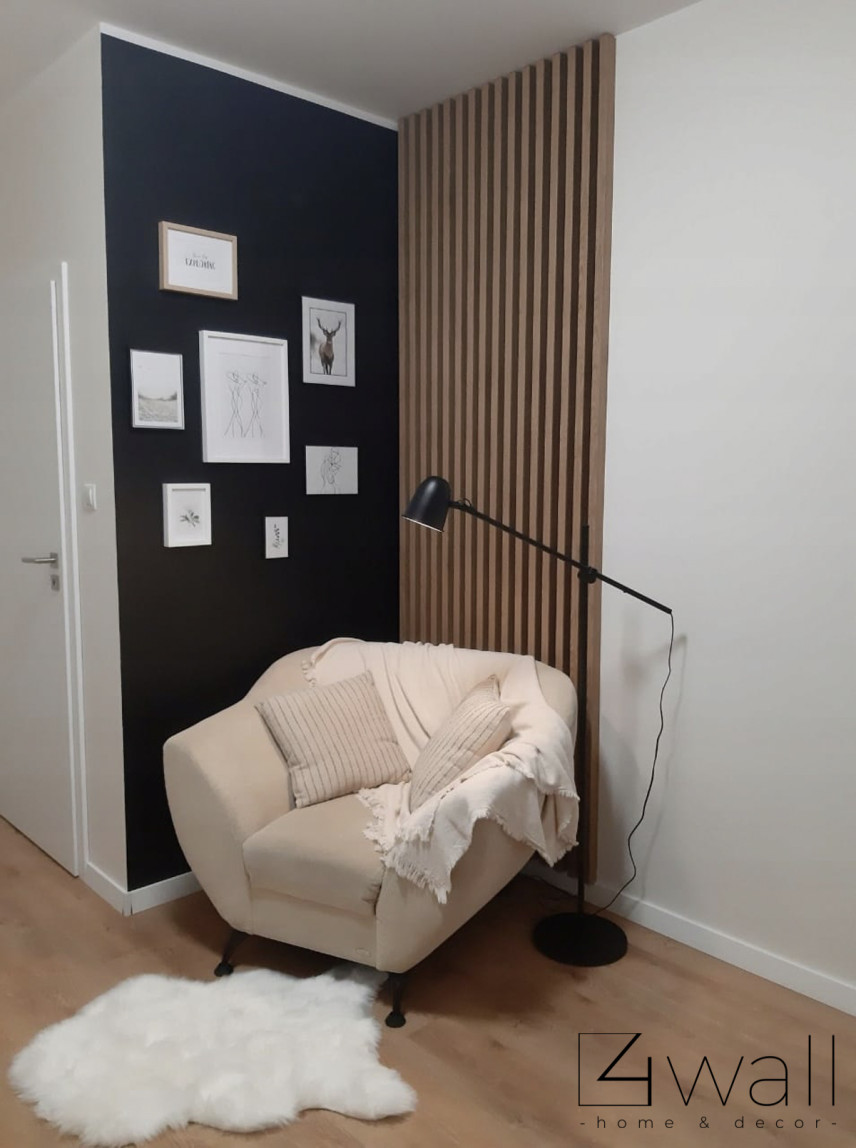 Przytulny kącik z lamelem drewnianym na ścianie oraz beżowym fotelem