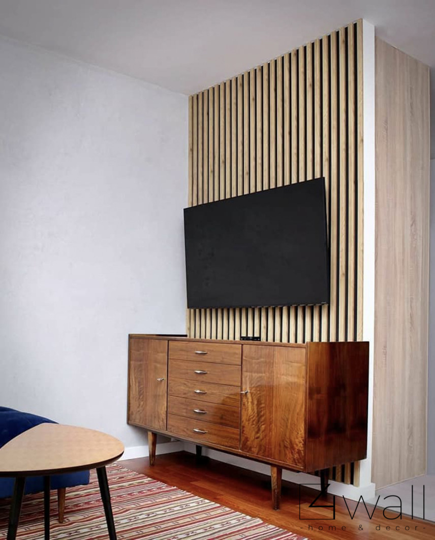 Salon z komodą z czasów PRL-u oraz z telewizorem zamontowanym na drewnianym lamelu