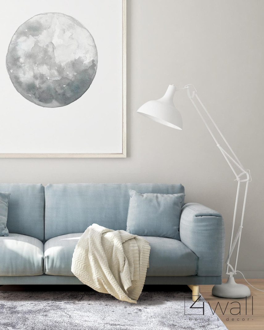 Klasyczny salon z niebieską sofą na drewnianych nogach, stylową lampą stojącą oraz modnym dywanem
