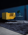 Salon z granatowym kolorem ścian oraz dywanem i żółtym, stylowym fotelem