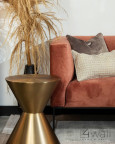 Salon z bordową sofą oraz pięknym stylowym stolikiem w złotym kolorze