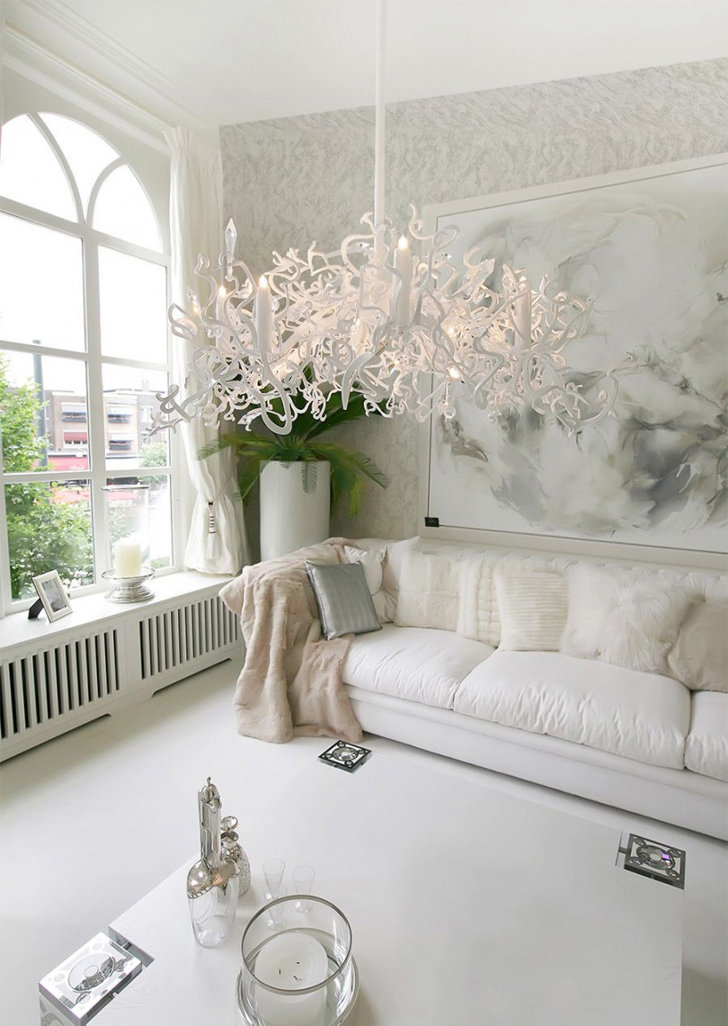 Salon w białej odsłonie z nietuzinkową lampą wiszącą