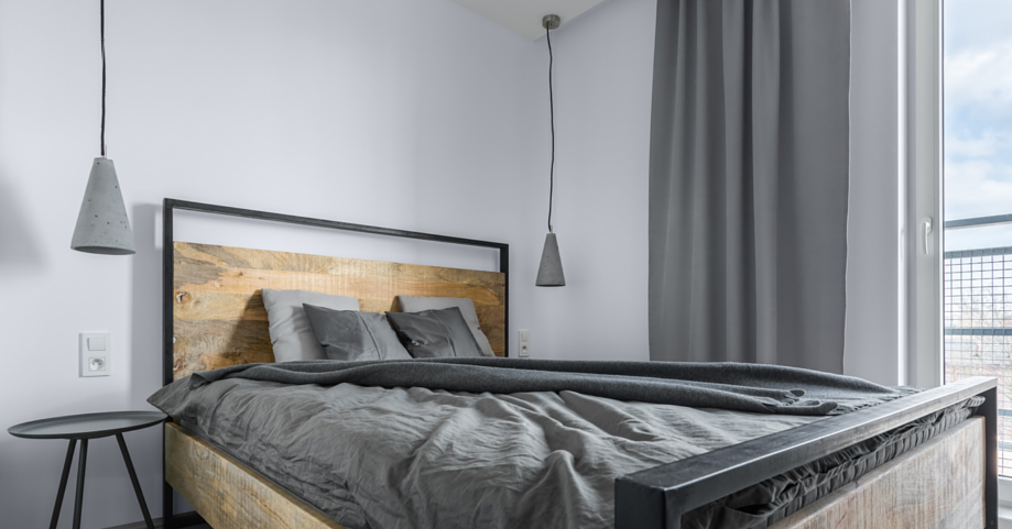 Sypialnia z dużym, drewnianym łóżkiem kontynentalnym
