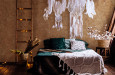 Sypialnia z brązowym kolorze na ścianie oraz z łapaczem snów wiszącym nad łóżkiem