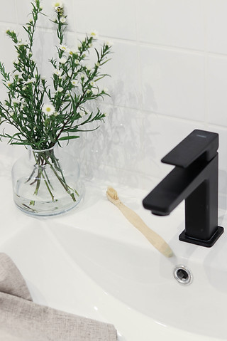 Łazienka z umywalką prostokątną oraz czarną armaturą łazienkową