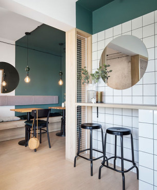 Salon w stylu industrialnym z butelkową zielenią na ścianie