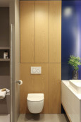 Łazienka z granatowym kolorem ścian oraz z motywem drewnianym