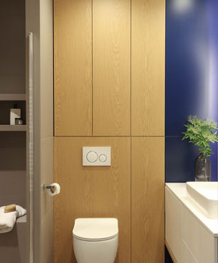 Łazienka z granatowym kolorem ścian oraz z motywem drewnianym
