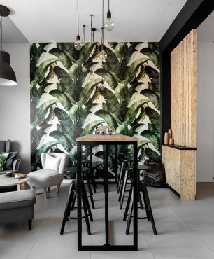 Salon z motywem botanicznym na ścianie oraz z szarymi meblami