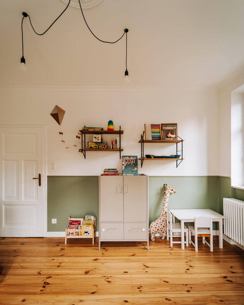 Pokój dziecięcy z meblami oraz półkami otwartymi zamontowanymi do ściany