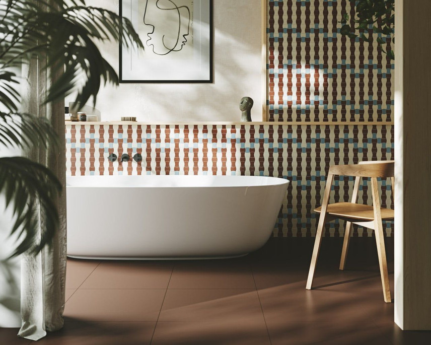 Łazienka z wanną ceramiczną oraz wzorzystymi płytkami na ścianie i brązową podłogą