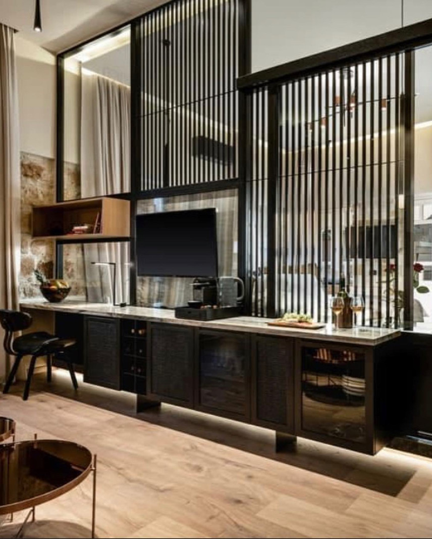 Salon w stylu industrialnym z lemelem w kolorze czarnym oddzielającym kuchnię