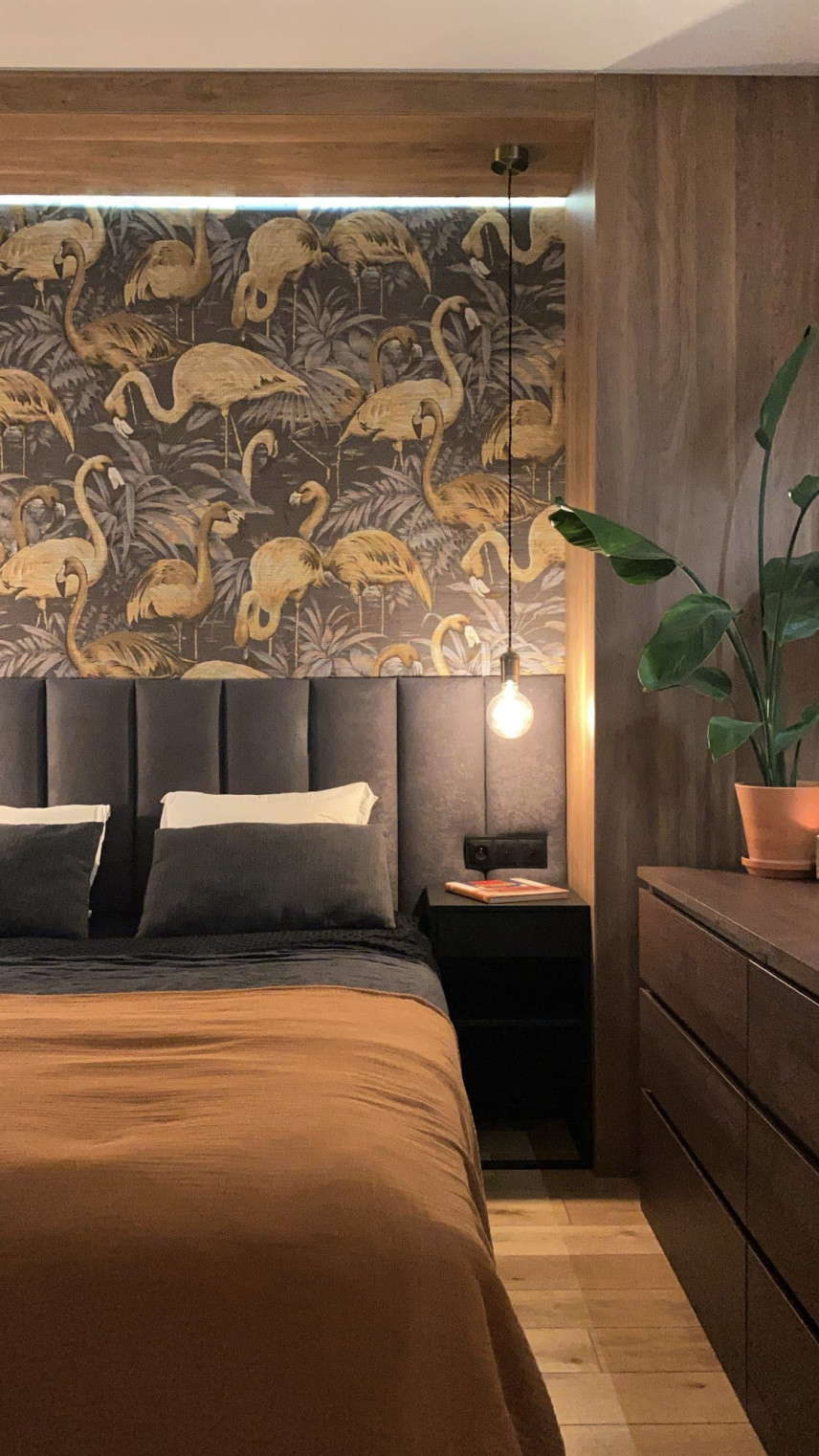 Sypialnia z tapetą w ptaki na ścianie oraz z panelem tapicerowanym za łóżkiem kontynentalnym