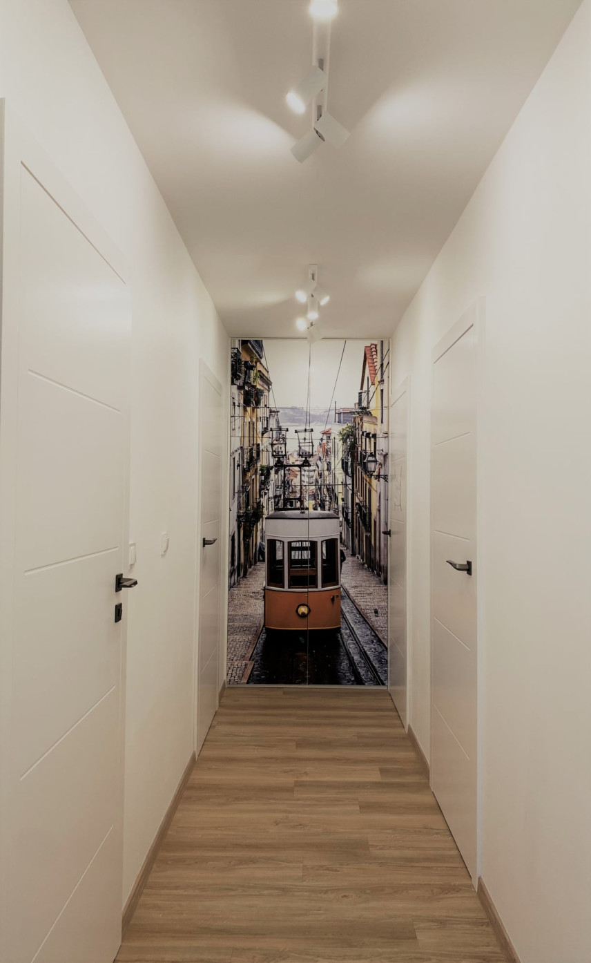 Biały, nowoczesny korytarz z fototapetą na szafie we wnęce