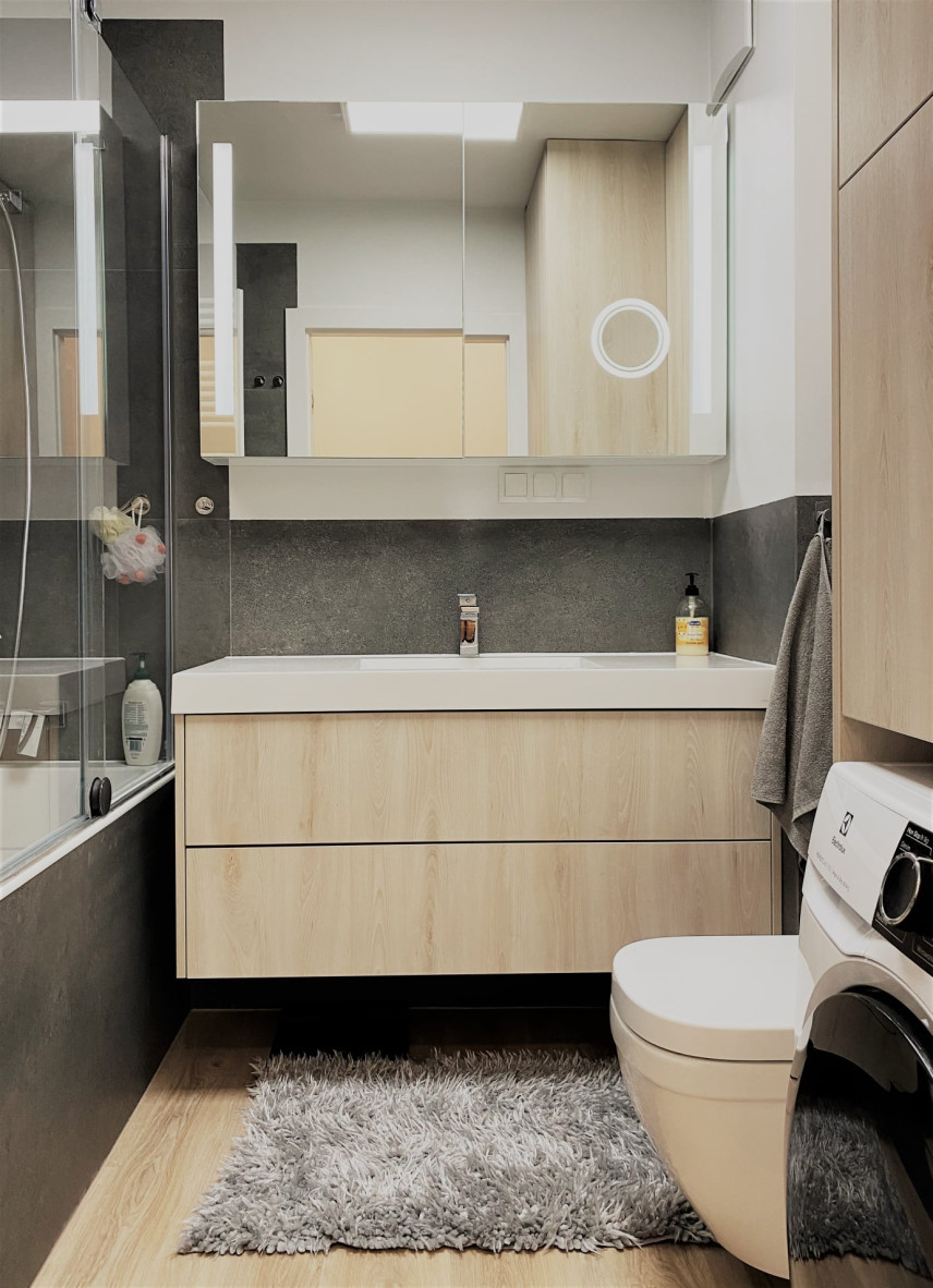 Mała łazienka z drewnianą szafką wiszącą oraz ceramiczną umywalką nablatową