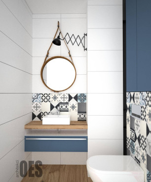 Projekt łazienki z okrągłym lustrem, w drewnianej ramie oraz z białą muszlą wiszącą