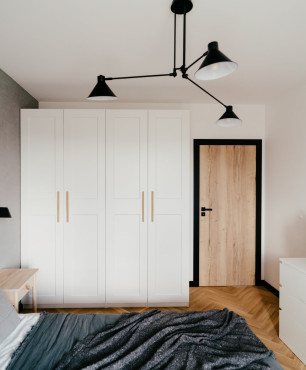 Sypialnia z szafą z białymi frontami oraz z drewnianym parkietem