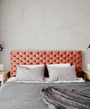 Sypialnia z łóżkiem kontynentalnym i tapicerowanym, pikowanym zagłówkiem w kolorze pomarańczowym
