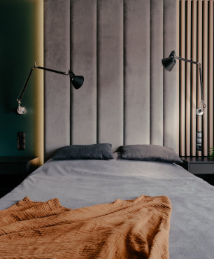 Sypialnia z tapicerowanymi panelami na ścianie w kolorze szarym oraz z toaletką z eliptycznym lustrem