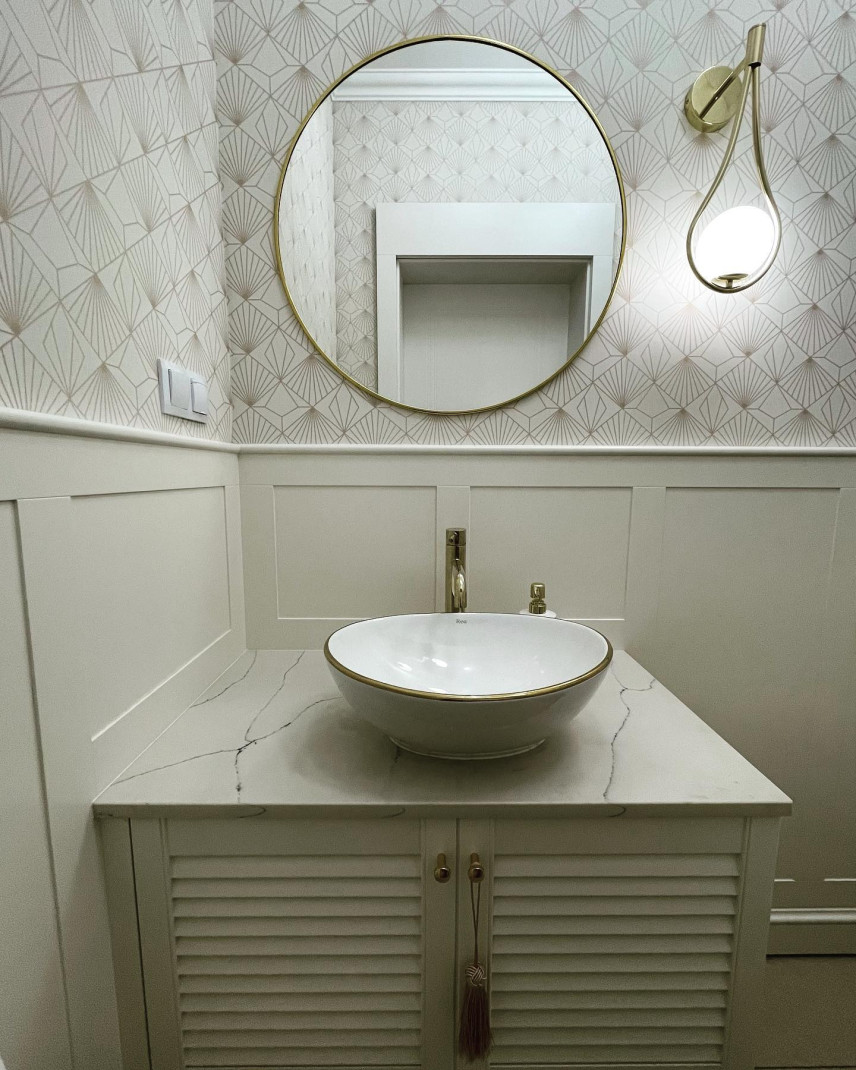 Piękna łazienka ze złotymi dodatkami, umywalką nablatową oraz blatem ze spiekiem kwarcowym