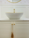 Łazienka z ceramiczną umywalką nablatowa ze złotą otoczką