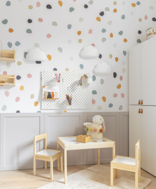 Nowoczesny pokój dziecięcy z tapetą w kropki na ścianie, szafą stojącą oraz stolikiem