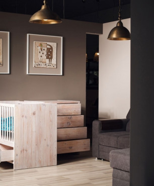Drewniane łóżeczko w pokoju dziecięcym z brązowym kolorem ścian