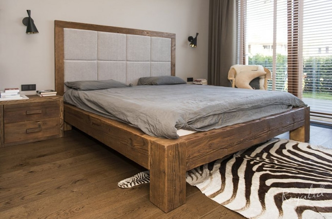 Piękne łóżko w drewnianej oprawie z drewnianymi panelami na podłodze