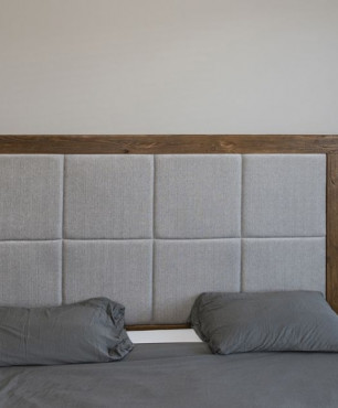 Sypialnia z drewnianym łóżkiem z tapicerowanym zagłówkiem