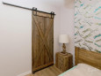 Drewniane drzwi przesuwne oraz dębowa szafka nocna w sypialni