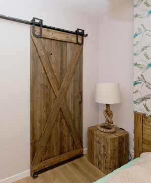 Drewniane drzwi przesuwne oraz dębowa szafka nocna w sypialni