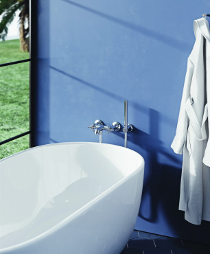 Łazienka z białą, owalną wanną ceramiczną oraz chromowaną armaturą prysznicową