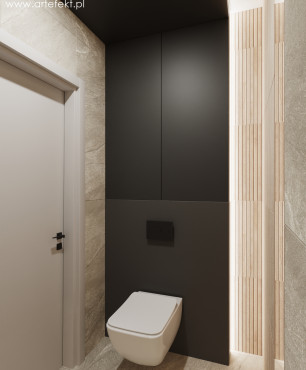 Mała toaleta z czarną ścianą oraz systemem spłukiwania zamontowanym w ścianie