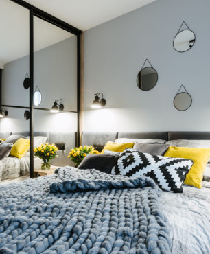 Sypialnia z szafą we wnęce z lustrzanym frontem oraz z tapicerowanym łóżkiem kontynentalnym