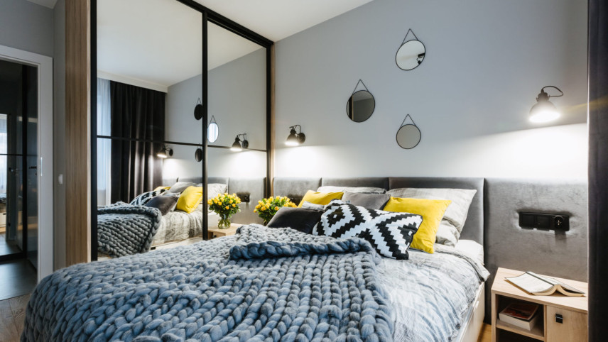 Sypialnia z szafą we wnęce z lustrzanym frontem oraz z tapicerowanym łóżkiem kontynentalnym