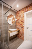 Łazienka z prysznicem w stylu skandynawskim z czerwoną cegłą na ścianie