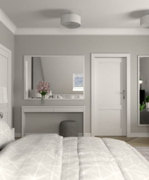 Sypialnia z szarym panelem tapicerowanym na ścianie, szarymi zasłonami oraz szarym kolorem ścian