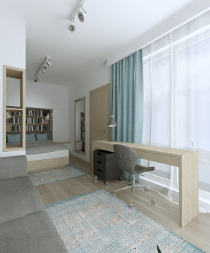 Sypialnia połączona z salonem oraz drewnianymi biurkiem