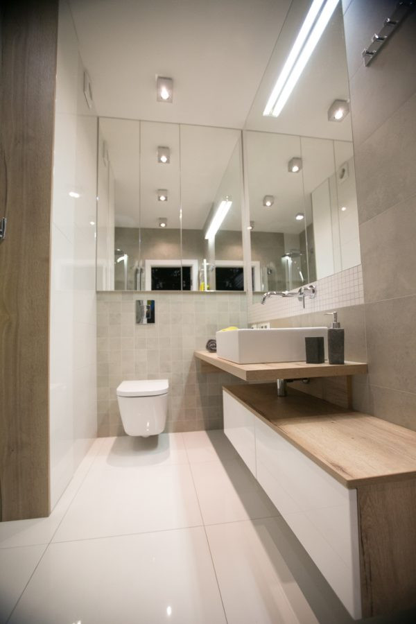 Klasyczna łazienka z białą muszlą wiszącą oraz białymi wielkoformatowymi płytkami na podłodze