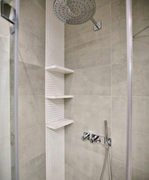 Łazienka z prysznicem podtynkowym oraz półką montowaną do ściany