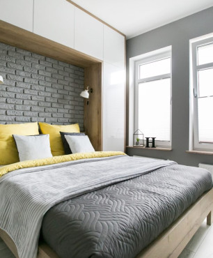 Mała sypialnia z biało-drewnianą zabudową nad łóżkiem