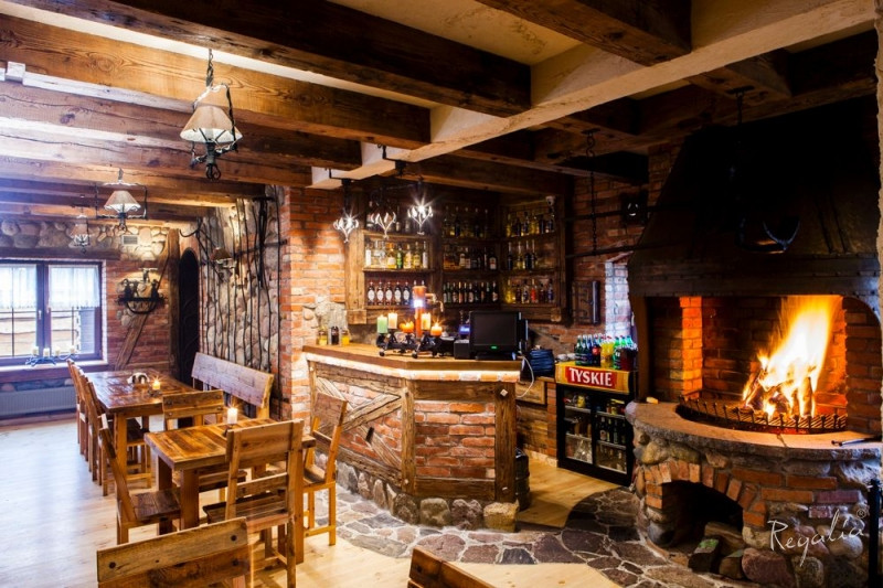 Restauracja w stylu rustykalnym z drewnianymi belami na suficie