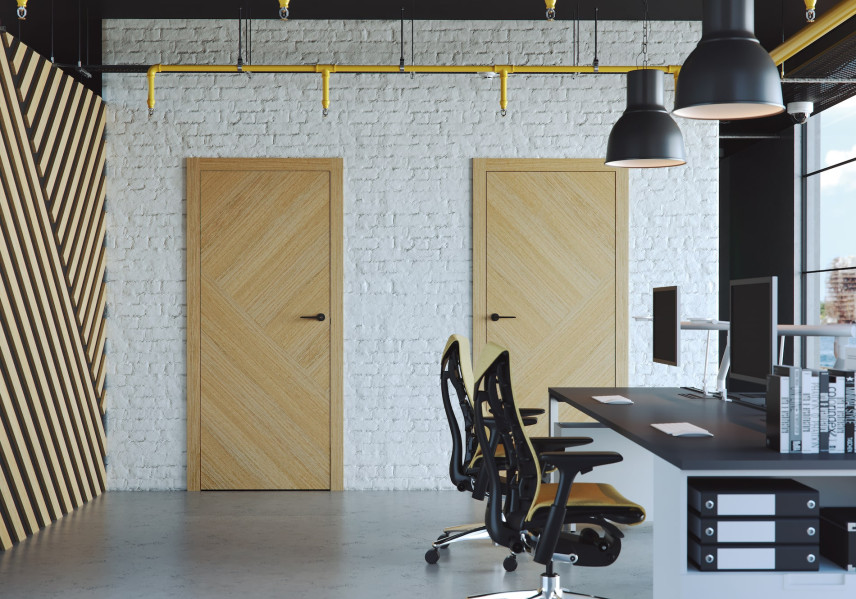 Pomieszczenie biurowe z podwójnym biurkiem oraz z drzwiami z jasnego drewna