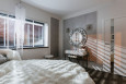 Piękna sypialnia z dużym oknem, imitacją betonu na ścianie, toaletką z okrągłym lustrem