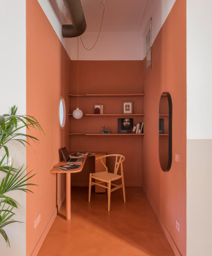 Mały gabinet domowy z odcieniem koloru pomarańczowego na ścianie