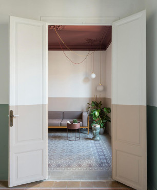 Widok na salon z wzorzystymi płytkami na podłodze oraz z brązowym sufitem