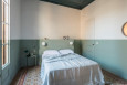 Klasyczna sypialnia z łóżkiem kontynentalnym oraz kinkietami na ścianie