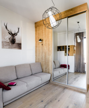 Klimatyczny salon z szafą w zabudowie oraz drewnem na ścianie